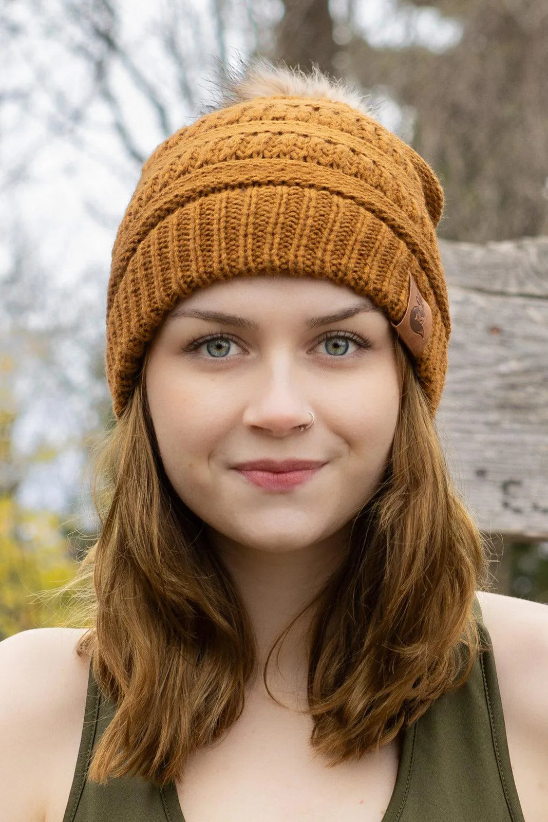 Woman wearing Sequoia ribbed knit beanie with pom outdoors