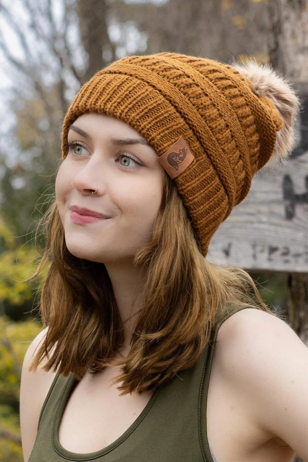 Side view of woman wearing Sequoia ribbed knit beanie with pom outdoors
