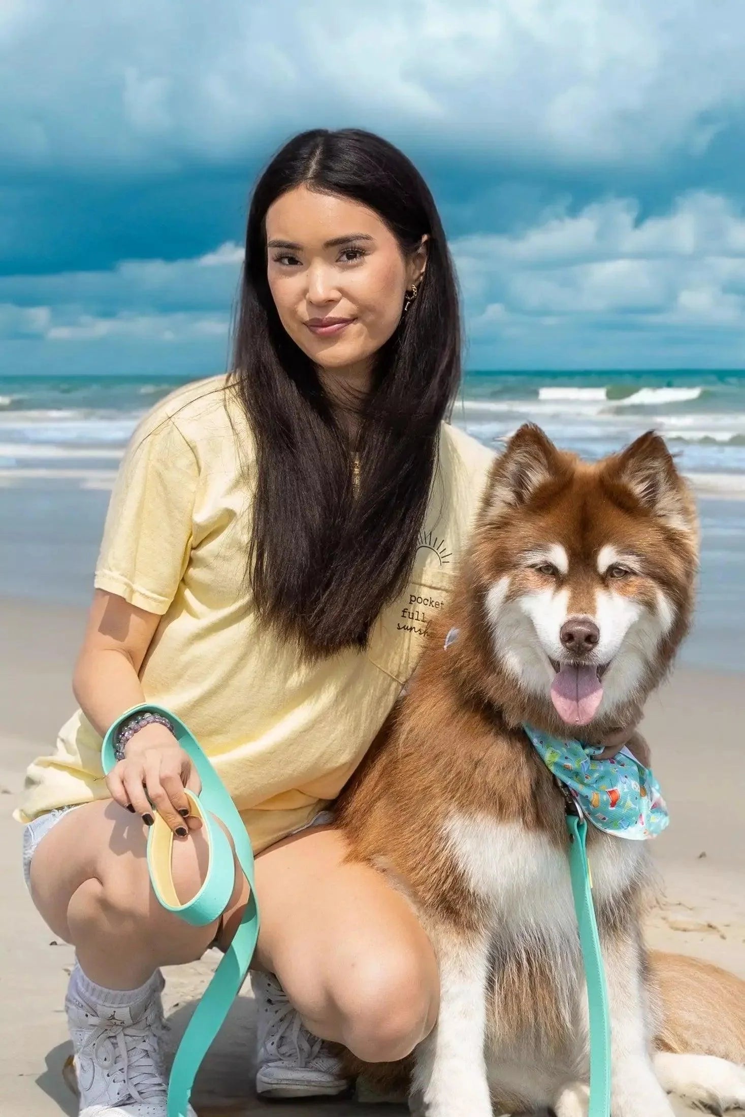 Woman walking dog with Island Vibes waterproof turquoise leash at the beach